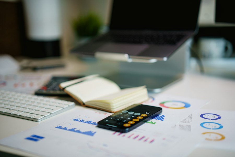 Escritorio de oficina con calculadora, portátil y gráficos financieros